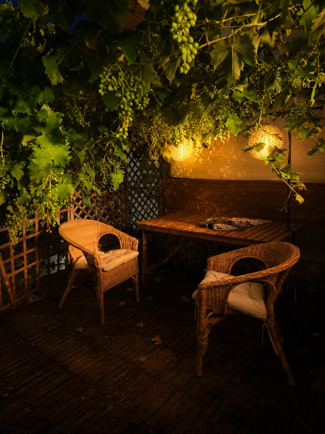 Farolillos encendidos sobre la mesa bajo la parra, de noche